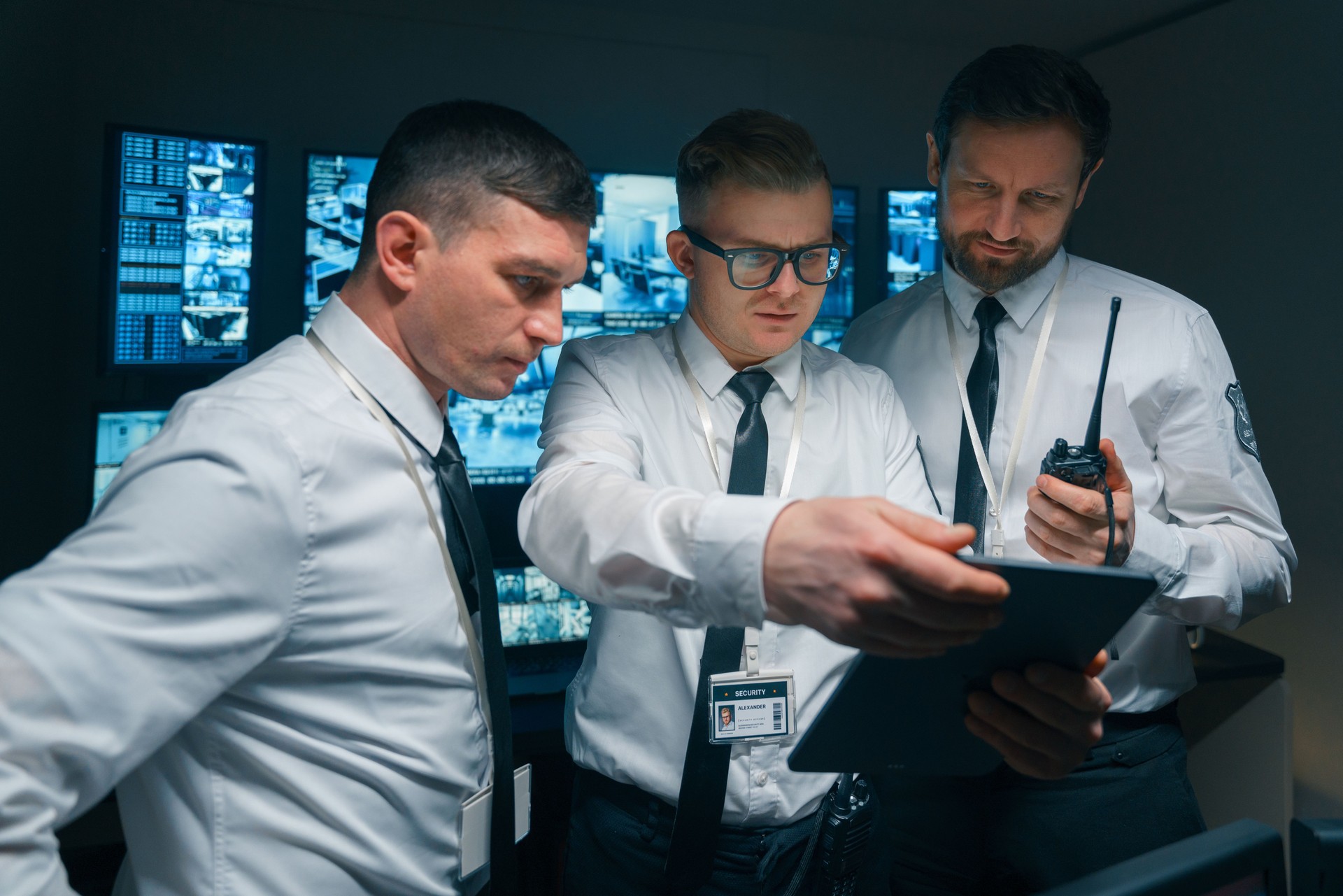 A group of security guards study the new instructions on a digital tablet.
